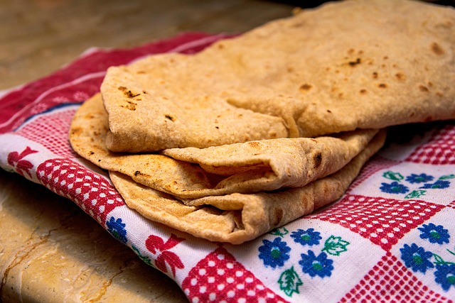 Three Chapatis stacked on top of each other on a red cloth